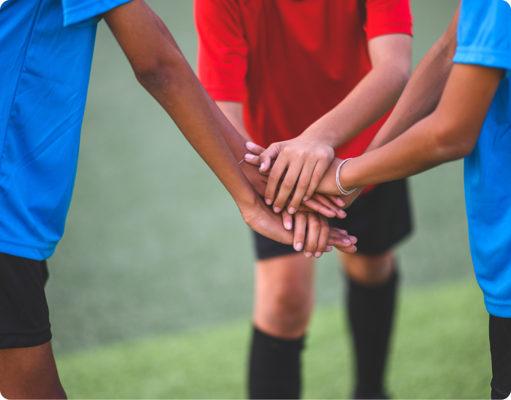 Young football players celebrating on a grassroots football pitch, representing community engagement and the Community Club App Launch package.